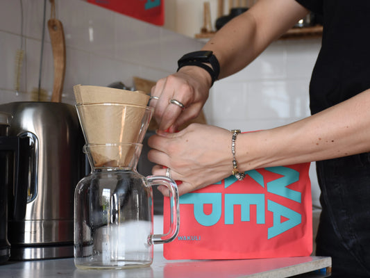 Hoe lang is koffie houdbaar | Iemand opent een zak koffie in modern keuken