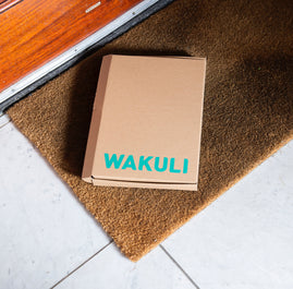 Duurzame koffiecups - Wakuli koffiecups in een kartonnen doos op een deurmat