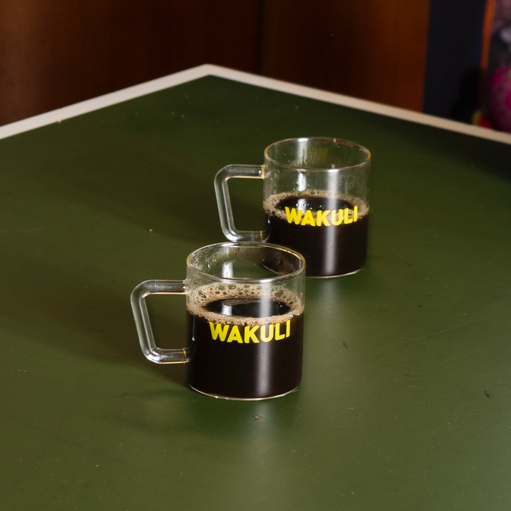Wakuli's Spicy Robusta koffie - Twee Wakuli koffiekopjes met zwarte koffie staan op een pingpongtafel.
