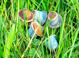 Duurzame koffiecups - 5 composteerbare koffiecups liggen in het gras.